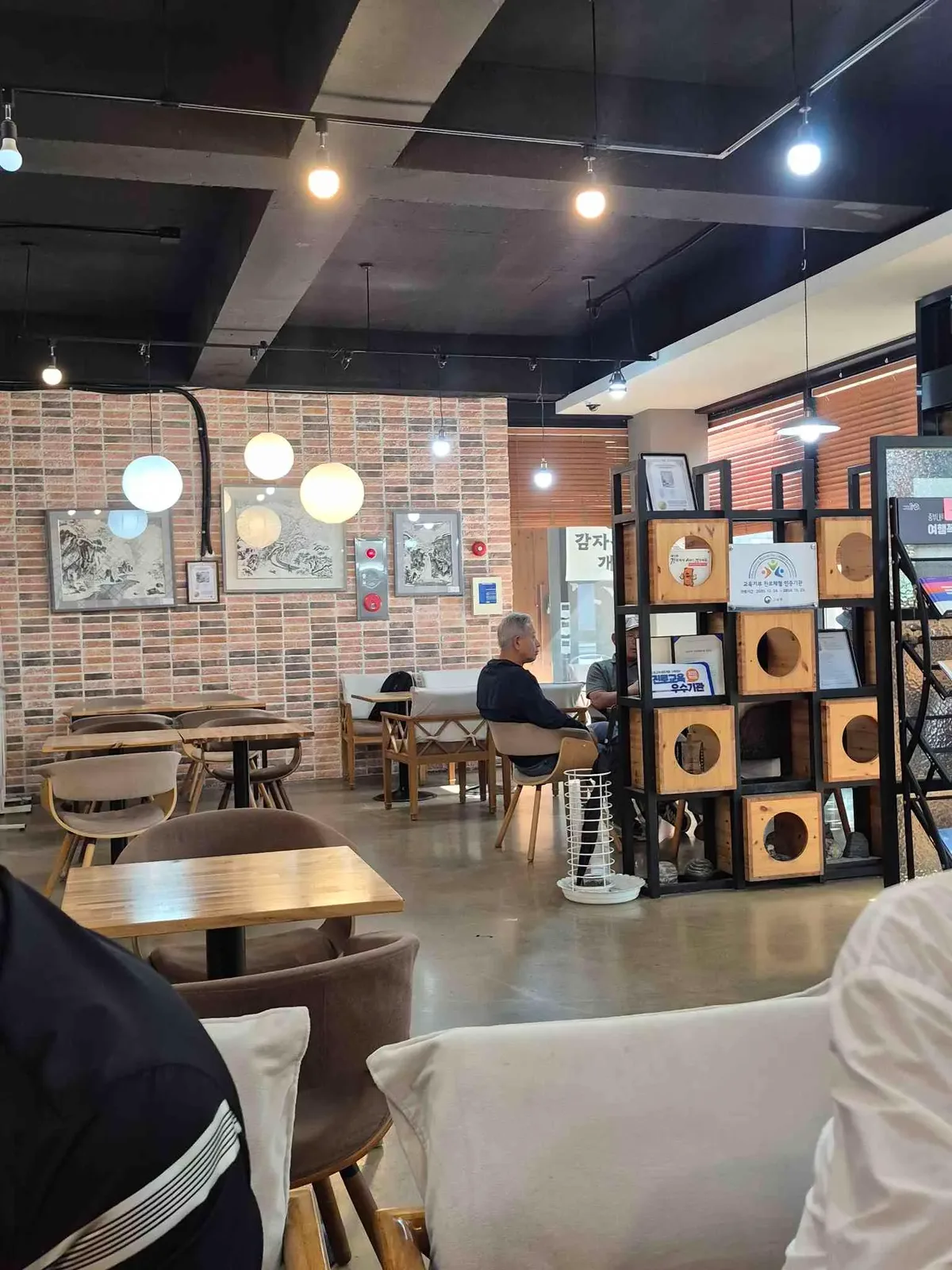 벽돌 벽과 원목 테이블이 놓인 이달엔영월 카페 내부